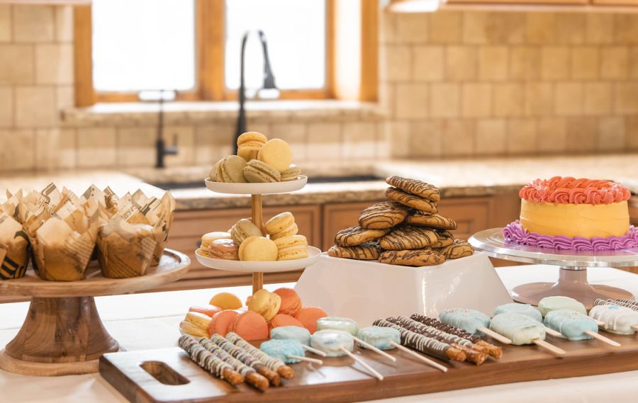 A table of muffins, macarons, cookies, cake pops and a celebration cake